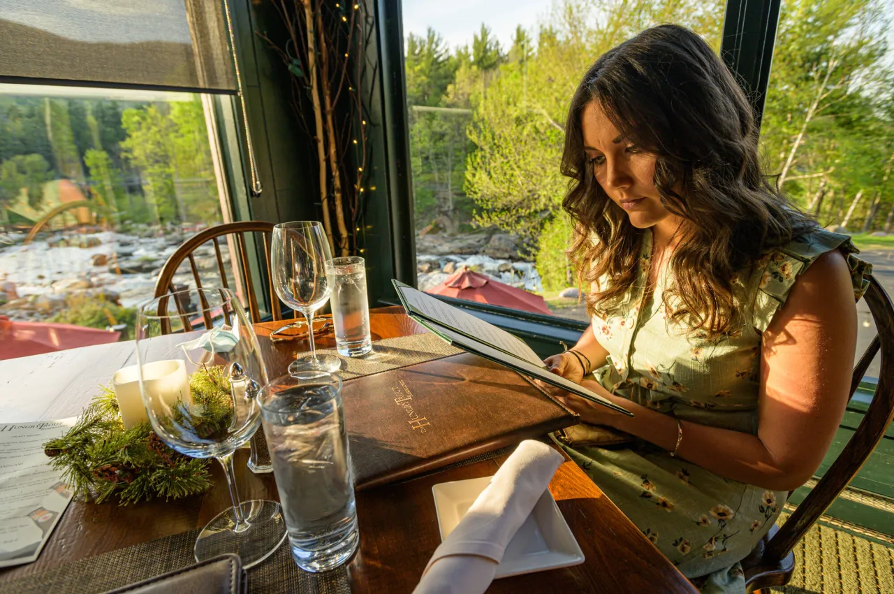 A woman looks at a dinner menu