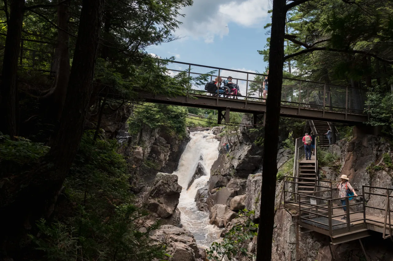 People walking on bridges and walkways around a scenic waterfall