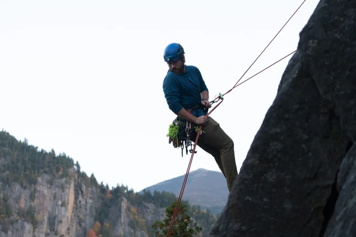 A climber rappels off a slab