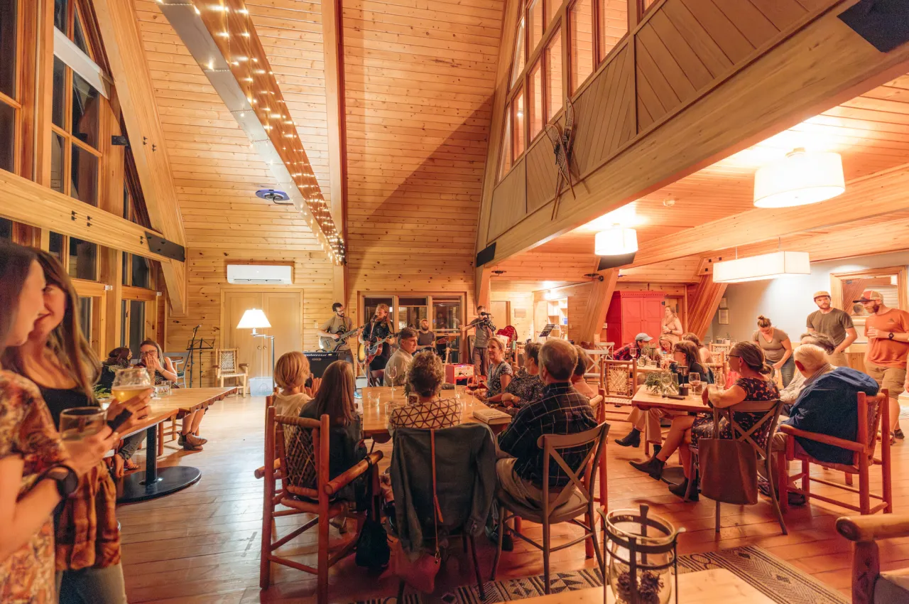 A gathering of people in a wooden a-frame building.