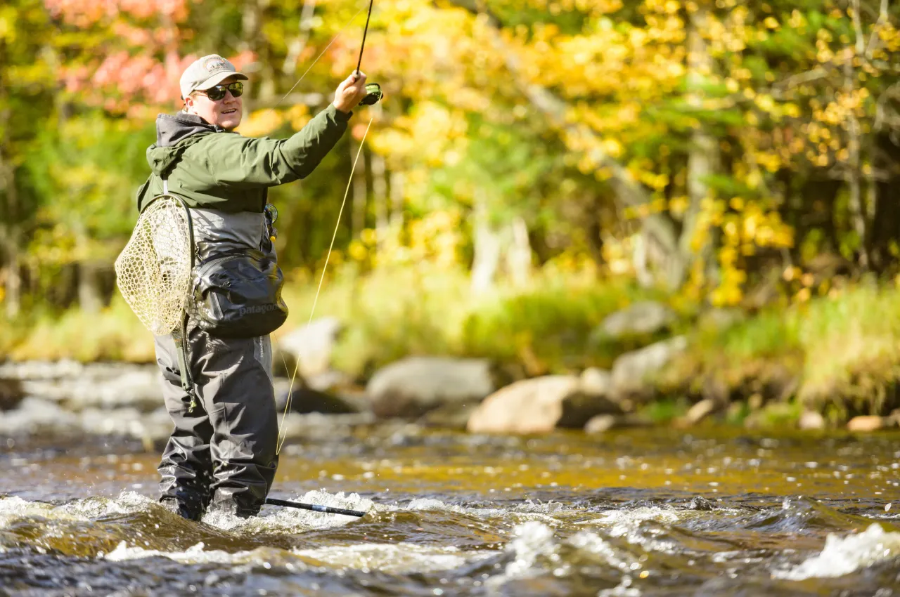 A man casts a line into the river. 