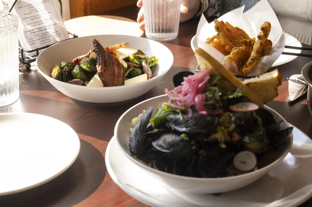 plates of oysters, brussel sprouts, and french fries