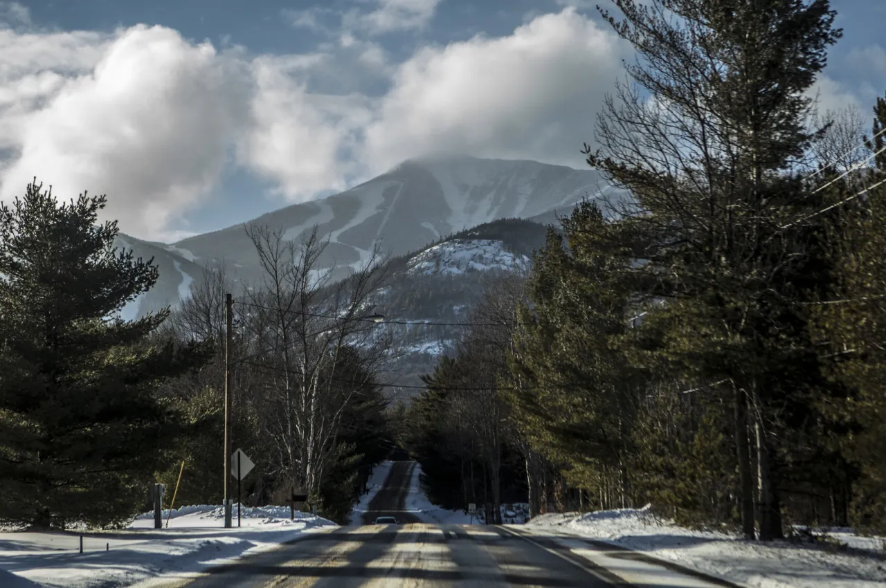 A road leading up to a giant mountain in winter. 