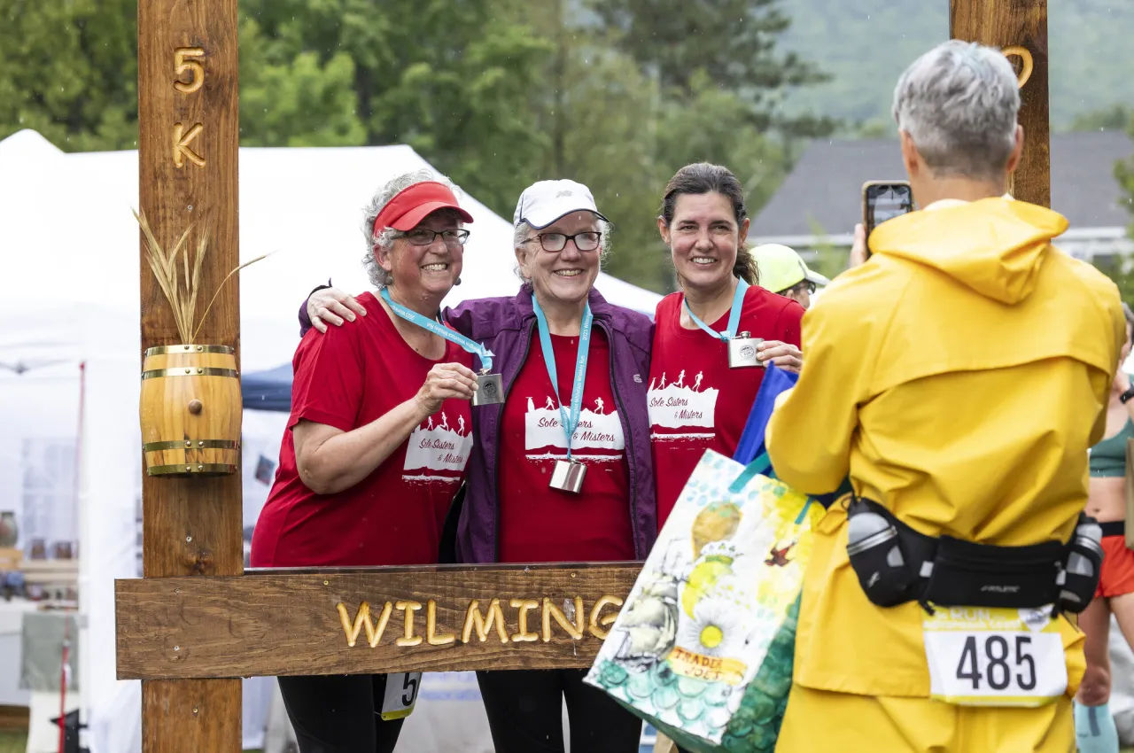 A group of women take a picture with their medals after a race.