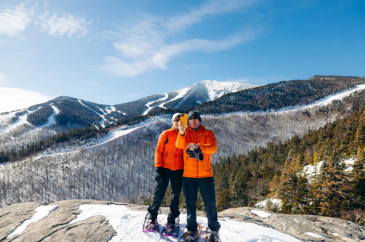Snowshoers taking a photo with Whiteface Mountain in the background.