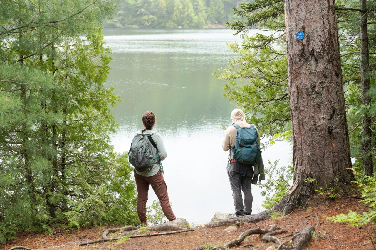 Two hikers standing by the water.
