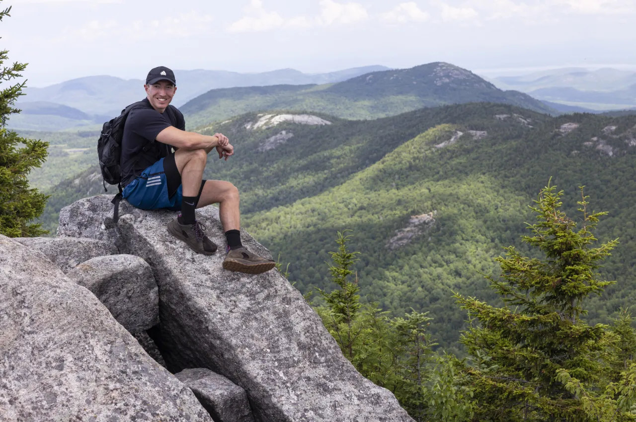 A man sits on top of a mountain