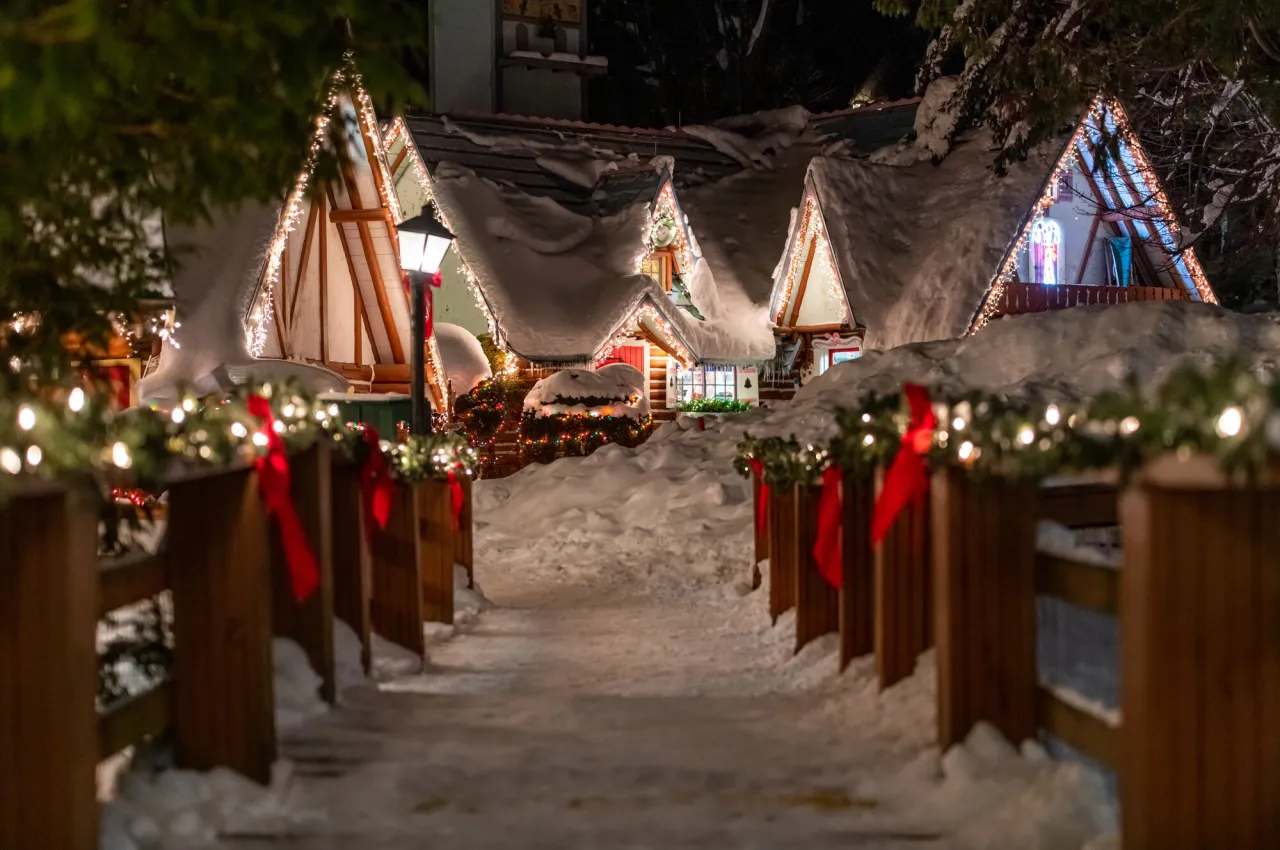 An entrance to a Christmas village covered in snow. 