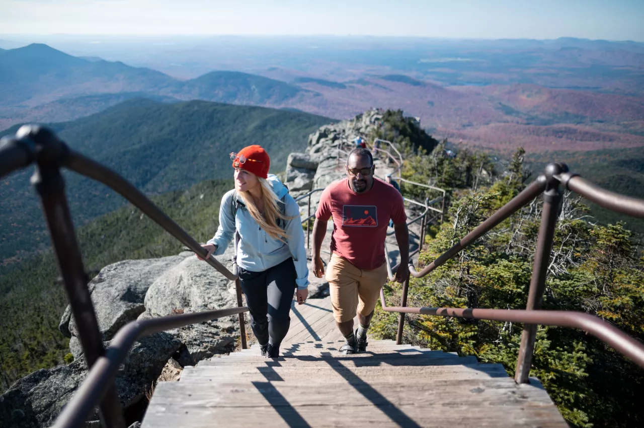 Two hikers walk up Whiteface's ridgeline using guard rails