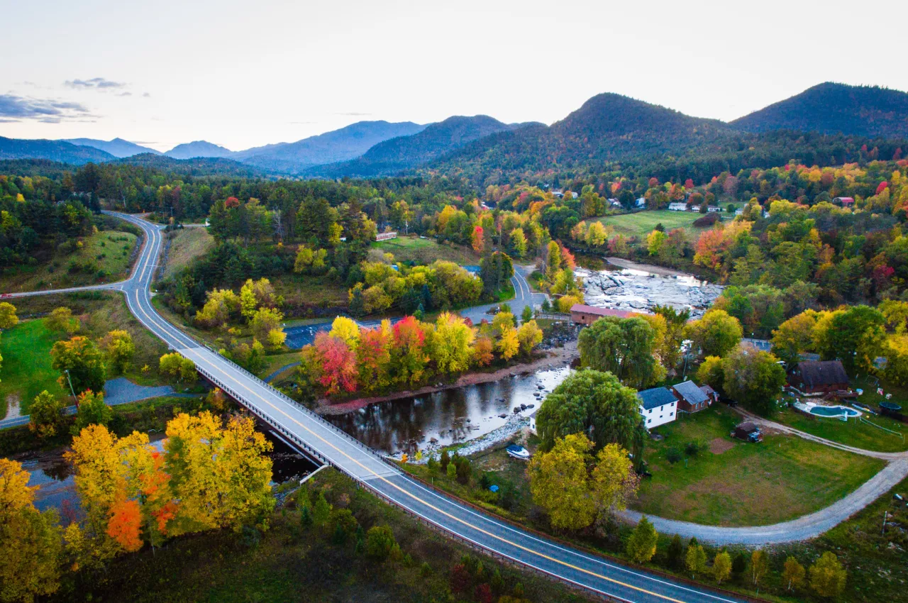 an aerial view of a small town in fall with a river running through it. 