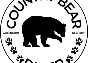 A circular logo reading Country Bear Diner with a silhouette of a bear in the center and some paw prints