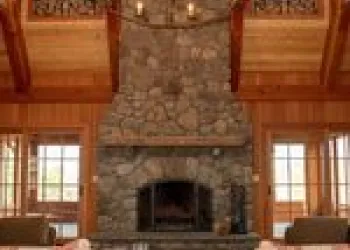 A large stone fireplace in a grand living room.