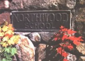 A metal placard reading Northwood School on a stone pillar