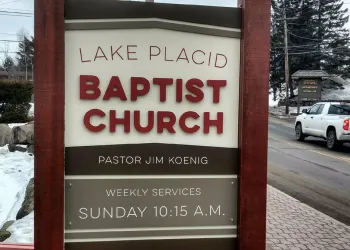 The brown sign with white background for the Lake Placid Baptist Church