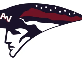 A profile of a man wearing a colonial hat with red