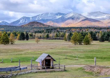 A farm stand with meadow and Whiteface Mountain in the distance.
