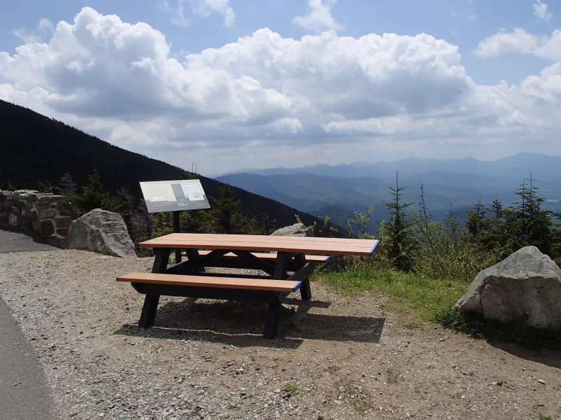 A picnic table at a pull-off on the Whiteface Veterans' Memorial Highway with the Adirondack mountains in the background