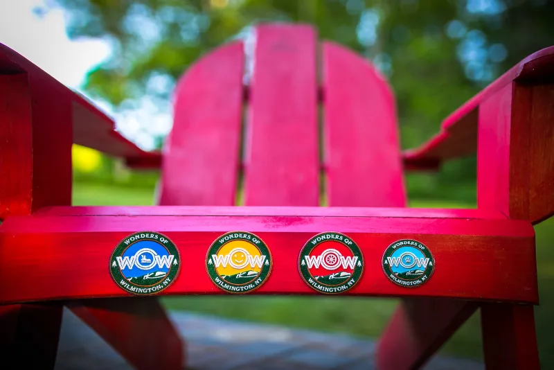 WOW patches on display on a red Adirondack Chair.