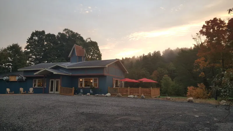 A view of the Adirondack Mountain Coffee Cafe's retro building, with a fall sunset in the background.