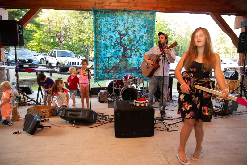 Adults and children performing live music.