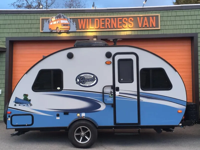 An oval shaped trailer is parked outside the Wilderness Van headquarters.