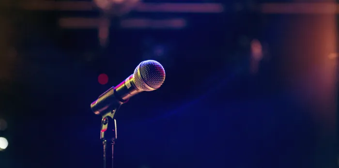 A close up of a microphone on stage in a dimly lit venue