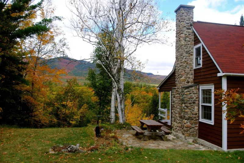 A red cottage looks out at Whiteface Mountain in the fall.