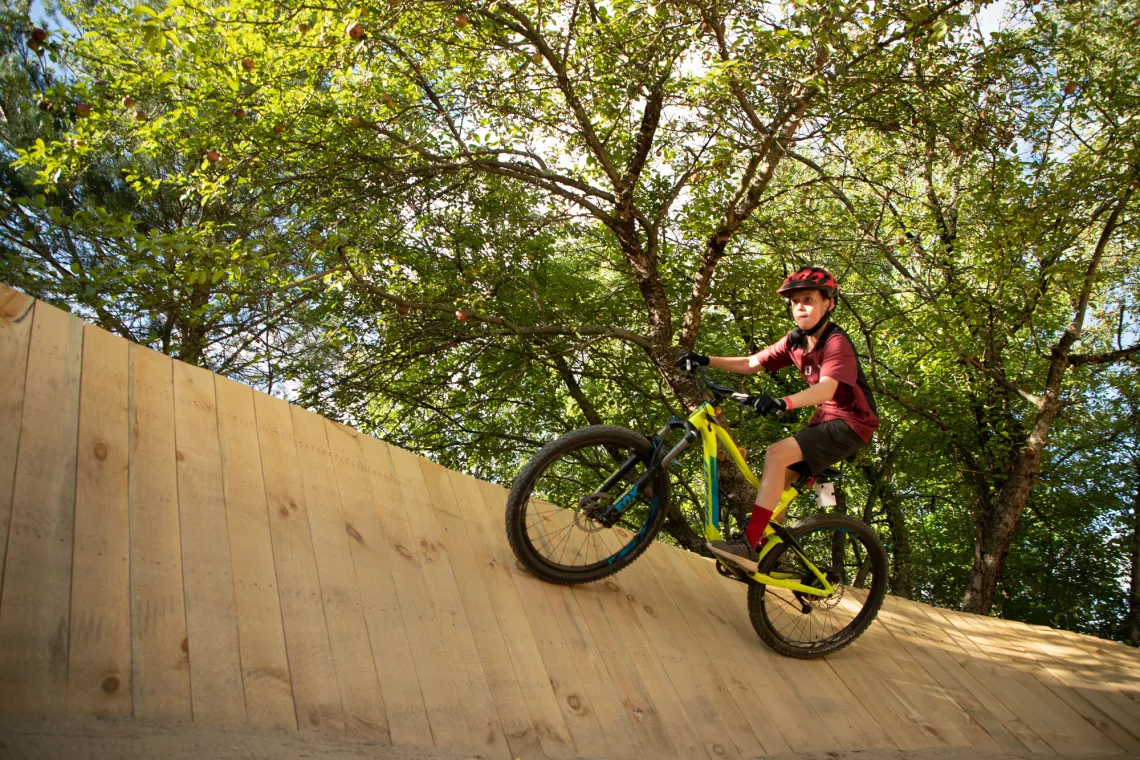 A boy focuses on riding a ramp on a bike.